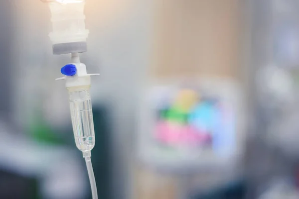 Set de perfusion IV et flacon sur un poteau. La solution saline liquide dégouline lentement des gouttes de médicaments, de médicaments ou d'antibiotiques et la récupération chirurgicale dans un hôpital ou une clinique, mise au point douce — Photo