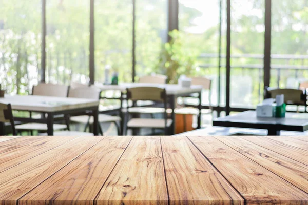 Tampo de mesa de madeira em branco com no restaurante ou café café desfocado fundo para montagem produto presente — Fotografia de Stock