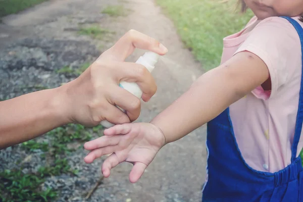 Spruzzando a mano insetti o repellenti per zanzare sulla pelle della ragazza, repellenti per zanzare per neonati, bambini che proteggeranno i tuoi bambini da zanzare e altri insetti — Foto Stock