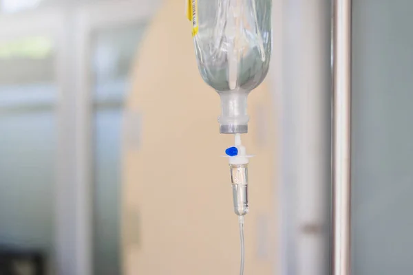 Intravenous therapy iv infusion set and bottle on a pole. Liquid saline is slowly dripping drops of drugs, medicine or antibiotic therapy and surgery recovery in a hospital or clinic — Stock Photo, Image