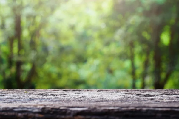 Старая деревянная столешница на зеленом размытом абстрактном фоне из листвы. Готовы использовать нас дисплей или монтаж продукции дизайн — стоковое фото