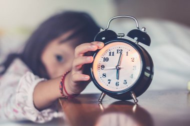 El kız sabah çalar saat çalar saat uyandığında çalar saat erteleme için uzanarak , saat kapatın