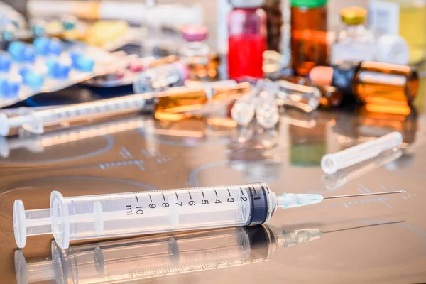 Üveg Medicine vials ampulla, gyógyszer tabletta és kapszula fecskendez az x-ray film mint orvos asztal háttér sekély DOF — Stock Fotó