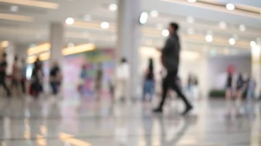 Bulanık insanlar koridorda yürürken maske takarak sergi fuarında alışveriş yapıyorlar.