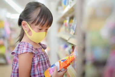 Çocuklar, marketten ürün almadan önce bileşenleri ve son kullanma tarihini görmek için tatlı etiketlerini okurlar. .