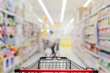 Süpermarketteki boş alışveriş arabası bulanık arkaplan.