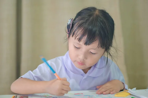 교복을 숙제그리기와 집에서 그림그리기를 아시아 소녀는 교사를 보내기 위하여 생각이었다 — 스톡 사진