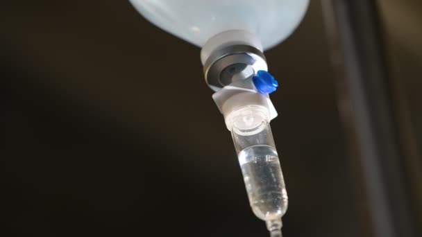 Close up soro fisiológico IV gotejamento Garrafa de infusão com solução IV para paciente em hospital de enfermaria — Vídeo de Stock