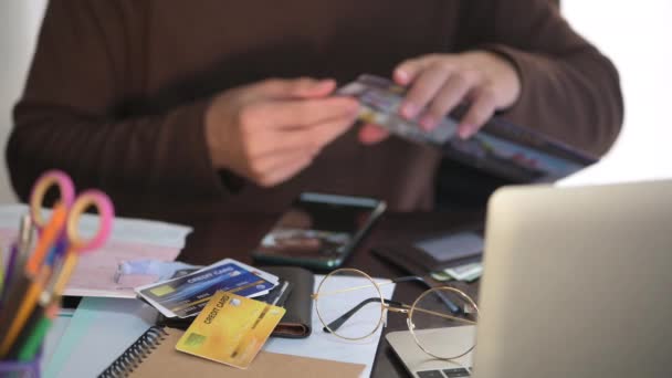 Hombre abierto y leer el estado de cuenta de la tarjeta de crédito de muchas tarjetas de crédito mientras trabaja en el escritorio, se centran en la tarjeta de crédito DOF poco profunda — Vídeos de Stock