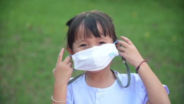 Nové normální: holčička nosí plátěnou masku na ochranu před nemocemi nebo znečištěním ovzduší její zvednout ruku ok držení těla — Stock video