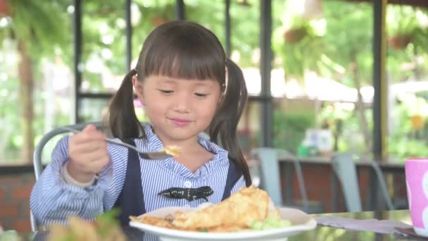 小さなアジアの子供の女の子が幸せな笑顔で朝の朝食を持っています — ストック動画