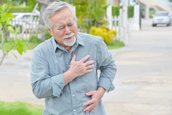 Senior asiatico uomo avendo doloroso petto infarto a all'aperto casa parco cardiopatia concetto — Foto Stock