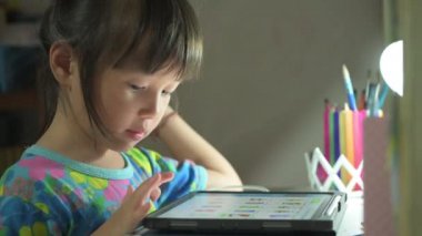 Asyalı çocuk oturma odasında dijital tablet kullanarak dinleniyor çizgi film izliyor eğitici online oyun konsepti