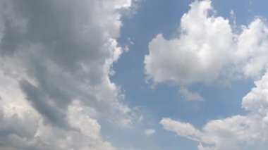 Mavi gökyüzü yağmur bulutları gökyüzünde hareket ediyor. Hızlı bulut oluşumu ve hareket gerçeküstü bir zaman atlaması yaratıyor.