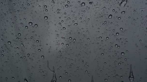 Yağmur mevsiminde cam camlarında gerçek yağmur damlaları kayar. — Stok video