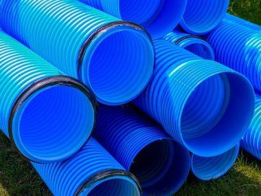 İnşaat alanında kullanılan mavi kıvrımlı polipropilen borular. Kurulum için çift katmanlı mavi PVC su boruları açıldı. Kapat.