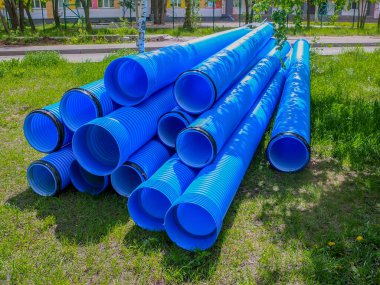 İnşaat alanında kullanılan mavi kıvrımlı polipropilen borular. Kurulum için çift katmanlı mavi PVC su boruları açıldı.