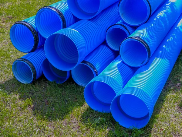 Blue corrugated polypropylene pipes used on the construction site. Double-layer blue PVC water pipes unpacked for installation.