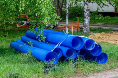 İnşaat alanında kullanılan mavi plastik borular ve beton halkalar. Kurulum için çift katmanlı mavi PVC su boruları açıldı.