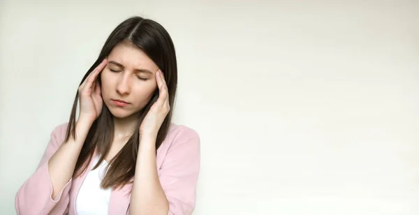 Portret młodej kobiety cierpiącej na ból głowy odizolowanej na szarym tle pracowni. — Zdjęcie stockowe