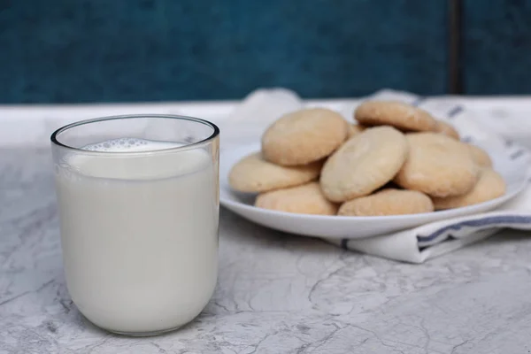 Close up van zelfgemaakte kokos koekjes en melk glas op plaat in een servet — Stockfoto