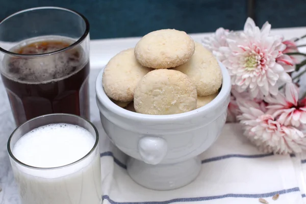 Nahaufnahme von hausgemachten Kokosgebäck Schokolade und Milchglas und Kaffee auf Teller in einer Serviette mit Blumen Chrysantheme — Stockfoto