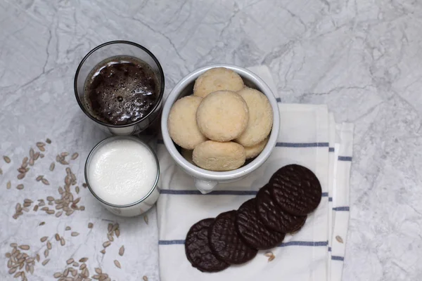 Close up van zelfgemaakte kokos koekjes chocolade en melkglas en koffie op de plaat in een servet wih bloem chrysant — Stockfoto