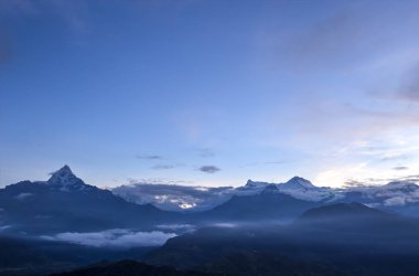 Machapuchare dağın (6,993 m) olarak da bilinen Fishtail dağ sabah mavi saatte gördün. Nepal Sarangkot Tepesi'nden görüntülemek.