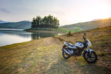 Endurance motorcycle on the shore of Ooty Lake waiting for the sun to set, Tamil Nadu, India. clipart