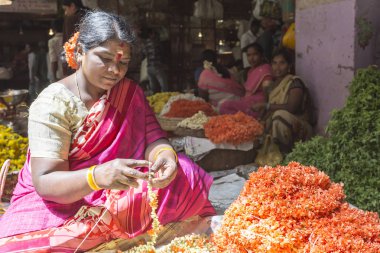 Hindistan, Karnataka, Bangalore 'daki renkli KR çiçek pazarında kalabalık bir günde kadın çiçekçi. Fotoğraf 3 Mart 2018 'de çekildi..