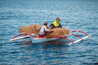 Bohol, Filipinler - Mar 2016: Balıkçılar ya bambu ya da rattan yapılmış geleneksel balık tuzakları taşıyan küçük bir balıkçı teknesinde.