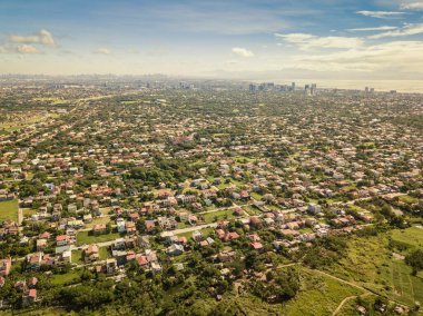 High Aerial of Katarungan Village, Ayala Alabang Village, and Metro Manila cityscape. Sheer size of built up area of Mega Manila. clipart