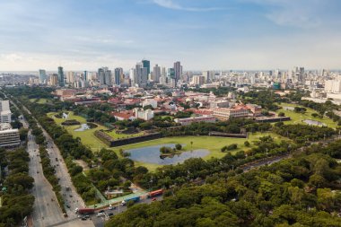 Manila, Philippines - Aerial of Intramuros, a historic walled area. surrounded by golf courses, and buildings. Intersection of Roxas Blvd and Padre Burgos Ave in front.. clipart