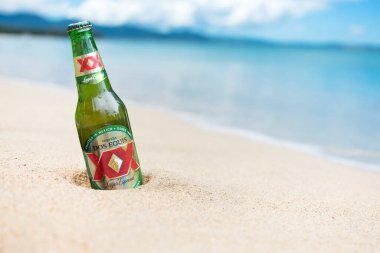 Filipinler - Temmuz 2020: Bir şişe Dos Equis Birası kısmen kumsala gömülebilir.