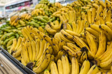 Yakın çekim olgun ve olgunlaşmamış muzlar süpermarketin meyve bölümünde satılıyor..