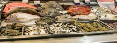 Farklı balık çeşitleri ve süpermarketin deniz ürünleri bölümünde karides..