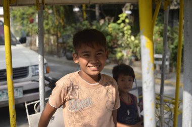 San Andres Bukid, Makati, Filipinler- Arkadaşlarıyla salıncakta sallanan gülen bir çocuk Manila 'nın gecekondu bölgesinde