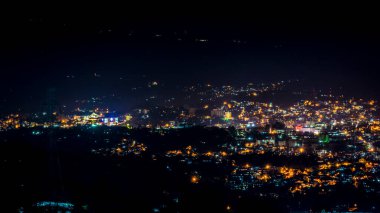 Baguio şehir manzarasının uzak bir görüntüsü. Gece vakti, dağ tarafından görüldüğü gibi..