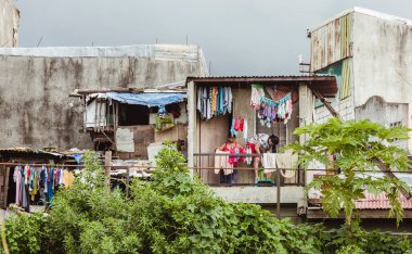 Manila, Filipinler - 2 kadın Manila 'nın varoşlarında kıyafetlerini asıyor..