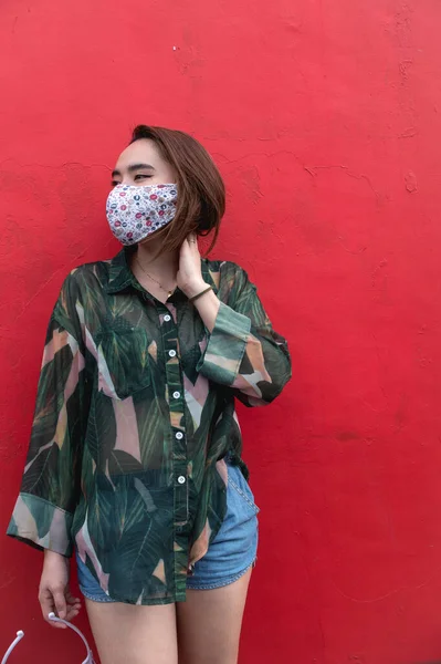 Seorang Wanita Asia Mengenakan Masker Wajah Berpose Oleh Dinding Merah — Stok Foto