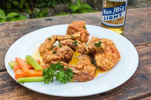 Filipinler - Eylül 2020 Sarımsaklı Parmesan Kanatları ve San Miguel Light Birası açık hava bahçesinde bir masada.