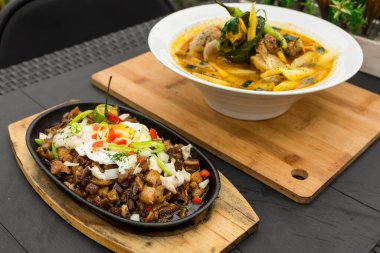 Pork Sisig ve Chicken Tinola, iki popüler Filipin yemeği..