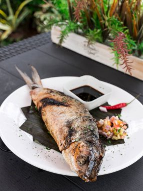 Sebzelerle doldurulmuş ızgara Kemiksiz Bangus soya sosu ve Atchara ile servis edilir. Bangus, Süt Balığı olarak da bilinir..