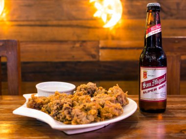 Manila, Filipinler - Ekim 2020 - San Miguel Süper Kuru Birası Calamares ile servis edilir ve meze olarak soslanır. Bir barda ya da barda..