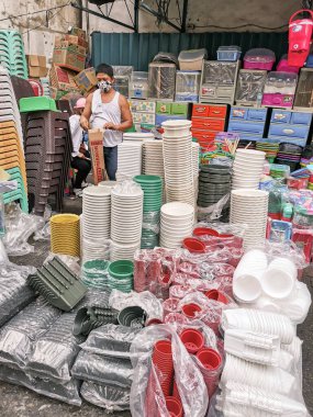 Divisoria, Manila, Filipinler - Ekim 2020: Tek bir satıcı Comerco Caddesi boyunca kapalı bir dükkanın önünde çeşitli plastik kaplar, sandalyeler ve diğer konteynerleri satıyor.