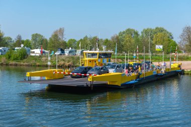 Megen, North Brabant/ Hollanda - 21 Nisan 2019: Meuse nehri boyunca araç ve yolcu taşımak için sarı feribot