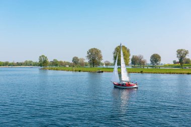Güneşli bir bahar gününde Meuse nehri üzerinde yelkenli gemi, Hollanda