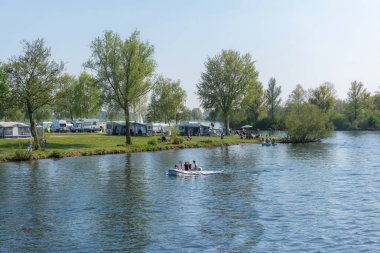 North Brabant/ Hollanda - 21 Nisan 2019: Çadırve kampçılarda Meuse nehri kıyısında dinlenin