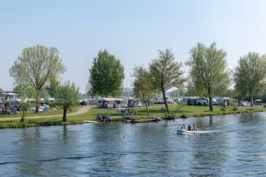Kuzey Brabant/ Hollanda - 21 Nisan 2019: Meuse nehri kıyısında ki çadır ve karavanlarda insanlar dinleniyor