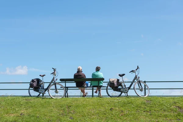 Veere, Zelandia/Holandia-6 czerwca 2019: dwie osoby Odpoczywaj na ławce po jeździe rowerem — Zdjęcie stockowe